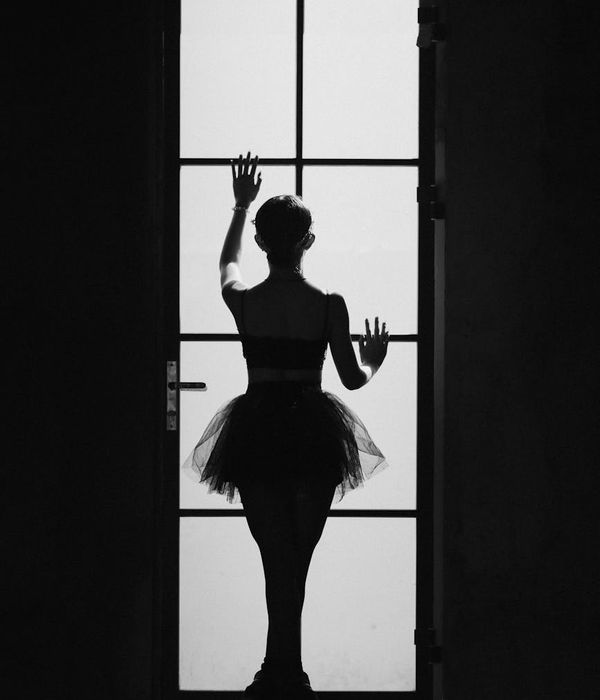 Woman performing a gentle cardio movement in a bright, minimalist room.